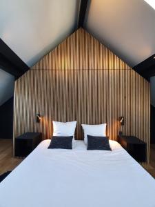 ein Schlafzimmer mit einem großen Bett mit zwei Kissen in der Unterkunft JAMES Résidence & Spa in Straßburg