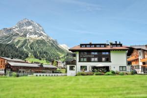 a large building with a mountain in the background at Haldenhof in Lech am Arlberg