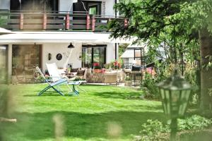 a house with a lawn with a chair and a lamp at Haldenhof in Lech am Arlberg