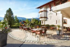 um pátio com mesas e cadeiras em frente a um edifício em Königshof Hotel Resort em Oberstaufen