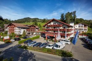 um hotel com carros estacionados num parque de estacionamento em Königshof Hotel Resort em Oberstaufen