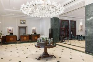 a large lobby with a chandelier and a table at Radisson Blu Carlton Hotel, Bratislava in Bratislava