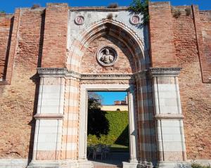 uma arcada num edifício de tijolos com uma estátua em Ostello S. Fosca - CPU Venice Hostels em Veneza