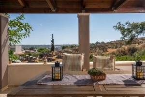 un patio con mesa, sillas y una ventana grande en Tholos Apartments, en La Canea