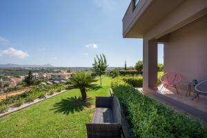 balcón con banco y vistas a un patio en Tholos Apartments, en La Canea