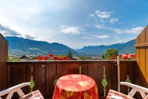 balcón con mesa, sillas y vistas a las montañas en Wiesengrund - Wohnung 5, en Tirolo