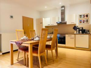 cocina con mesa de madera y sillas en Altstadthaus Buddha, en Erfurt