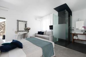 een slaapkamer met een groot bed en een bank bij Riva Suites - Adults Only in Mykonos-stad