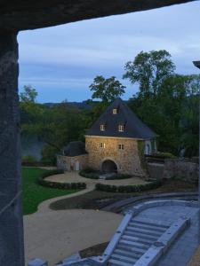 um grande edifício de pedra com um telhado preto em Le Château de Mirwart em Mirwart