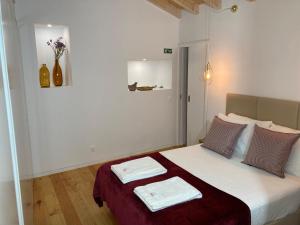 1 dormitorio con 1 cama con 2 toallas en Sefardita - Guest House, en Castelo de Vide