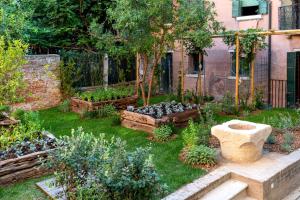 a garden with a stone bowl in the grass at Ca'di Dio-Small Luxury Hotel in Venice