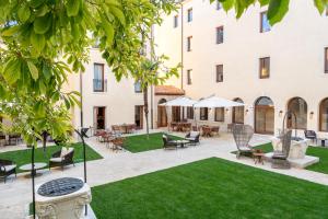 a courtyard with chairs and tables and a building at Ca'di Dio-Small Luxury Hotel in Venice