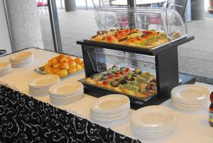 - un buffet avec des assiettes et de la nourriture sur une table dans l'établissement Gokart Hotel, à Kecskemét