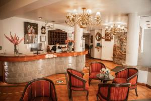 restauracja z barem z czerwonymi krzesłami i osobą w tle w obiekcie Hotel Hacienda Puno Centro Histórico w mieście Puno