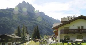 budynek z górą w tle w obiekcie Alpine Touring Hotel-petfriendly w mieście Pozza di Fassa