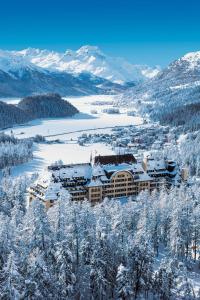 un complexe dans les montagnes avec des arbres enneigés dans l'établissement Suvretta House, à Saint-Moritz