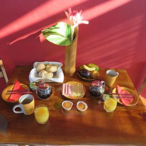 una mesa con un montón de comida y zumo de naranja en Micaval Residential, en São Tomé