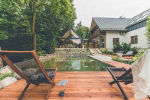 um quintal com uma piscina e duas cadeiras e uma casa em Łubinowe Wzgórze Dom II em Nałęczów