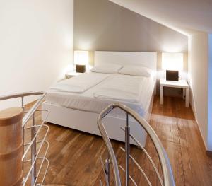 una camera con letto bianco e pavimento in legno di The Levante Rathaus Apartments a Vienna