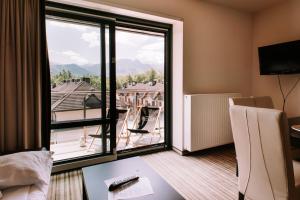 Cette chambre d'hôtel offre une vue sur un balcon. dans l'établissement Szklane Domy, à Zakopane