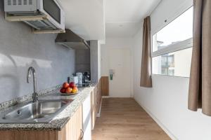 eine Küche mit einer Spüle und einer Arbeitsplatte in der Unterkunft Apartamentos Venecia in Lloret de Mar