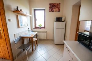 uma pequena cozinha com uma mesa e um frigorífico em Cracow Family House na Cracóvia