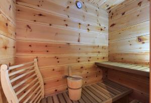 een houten sauna met een bank en een vuilnisbak bij Locanda4 in Valtournenche