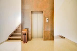 a hallway with stairs and a white door in a building at Mayfair Service Apartments in Pīlamedu