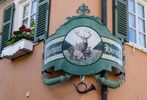 ein Schild an der Seite eines Gebäudes mit einem Hirsch in der Unterkunft Landhotel Hirsch in Tübingen