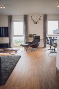 een kantoor met 2 stoelen, een bureau en 2 ramen bij Prime Park Penthouse Aschaffenburg in Aschaffenburg