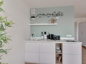 una cucina bianca con armadi bianchi e lavandino di limehome Darmstadt Wilhelminenstraße - Digital Access a Darmstadt