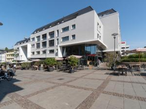 un edificio bianco con tavoli e sedie in un cortile di limehome Darmstadt Wilhelminenstraße - Digital Access a Darmstadt