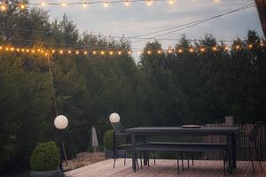 un tavolo e sedie su un patio con luci di Le Gîte du Puit des Granges a Fontaine-sur-Coole