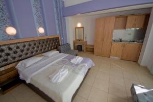 Un dormitorio con una cama con toallas blancas. en Blue Sea Beach Resort, en Skala Potamias