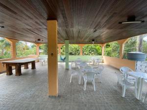 a pavilion with tables and white chairs and trees at CASA inteira entre Guaratiba e Campo Grande, Rio de Janeiro, RJ - a 40 min da praia, próximo ao Estádio Miecimo da Silva e Park Shopping-Ideal para descanso, encontros, festa e lazer-3000 m2 in Rio de Janeiro