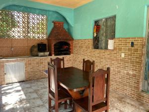 a dining room with a table and a brick oven at CASA inteira entre Guaratiba e Campo Grande, Rio de Janeiro, RJ - a 40 min da praia, próximo ao Estádio Miecimo da Silva e Park Shopping-Ideal para descanso, encontros, festa e lazer-3000 m2 in Rio de Janeiro