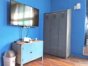 Cette chambre bleue dispose d'une télévision et d'un mur bleu. dans l'établissement Tainan MacArthur Homestay, à Tainan