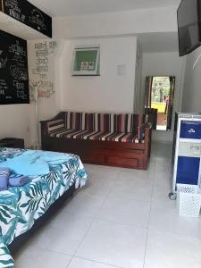 1 dormitorio con cama, sofá y TV en Hangar Rio Hostel, en Río de Janeiro