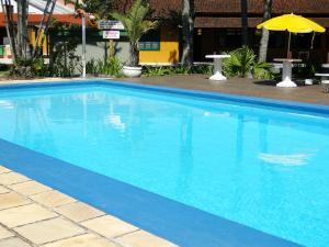 una gran piscina azul con sombrilla en Casa com piscina para família, en Florianópolis