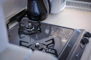 a stove top with a coffee pot on top of it at Blue Entrance in Onna