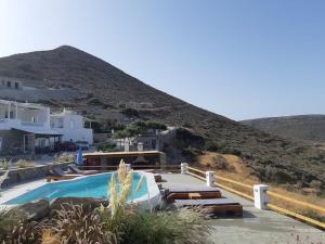 a swimming pool with a mountain in the background at 3 Paros *All Season* Villas in Parikia