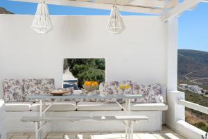 a white porch with a table and chairs at 3 Paros *All Season* Villas in Parikia