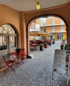 un patio extérieur avec des tables, des chaises et des parasols dans l'établissement Hotel Erbenhof, à Weimar