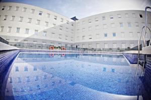 uma grande piscina em frente a um edifício em Apartamentos Vértice Sevilla Aljarafe em Bormujos