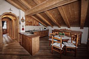 a kitchen with a table and some wooden cabinets at Appartamento Mainardi in Auronzo di Cadore