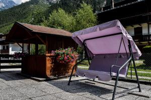 a large purple carriage sitting in front of a building at Appartamento Mainardi in Auronzo di Cadore