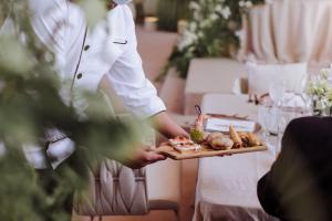 una persona che tiene un vassoio di cibo su un tavolo di Azul Talavera Country Club a Torreón