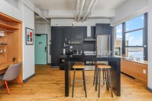 a kitchen with a black island with bar stools at Placemakr Wall Street in New York