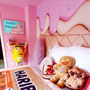 una camera da letto con un letto di buongiorno con una ciambella di Candypartment Sweets 'n Sleep a Gelsenkirchen