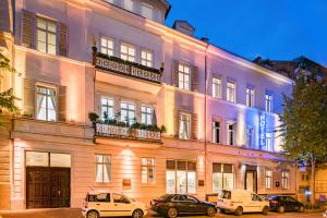 un grand bâtiment avec des voitures garées devant lui dans l'établissement Hotel Aurora, à Wiesbaden